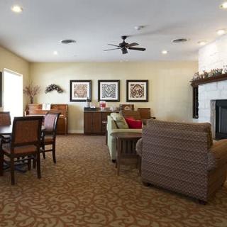 A cozy living room interior with a dining area, featuring sofas, a fireplace, and elegant decor.
