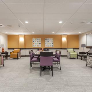 A modern meeting room with tables and chairs arranged for a conference.