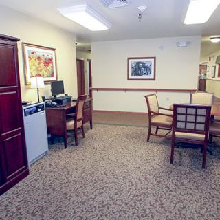 A furnished office space with desks, chairs, and artwork on the walls.