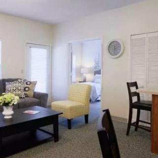A cozy living room with modern furniture and a small dining area.