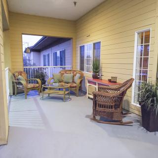 A cozy patio with wicker furniture and decorative plants.