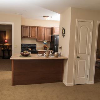A view of a kitchen with wooden cabinets and a countertop.