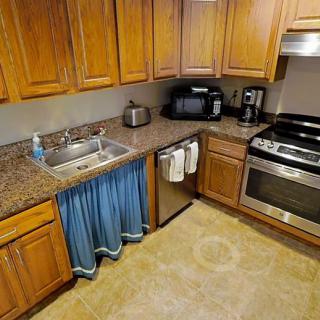 Modern kitchen with wooden cabinets, granite countertops, and stainless steel appliances.