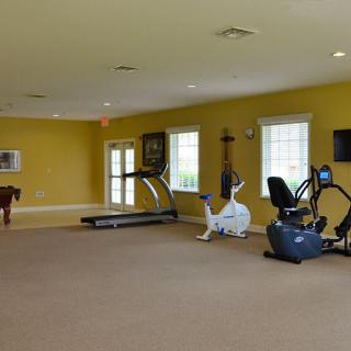 A spacious gym room with various fitness equipment including treadmills and exercise bikes.