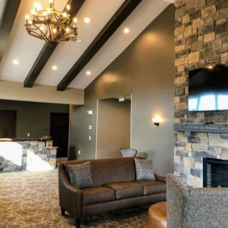 A modern living room with a stone fireplace and beamed ceiling.