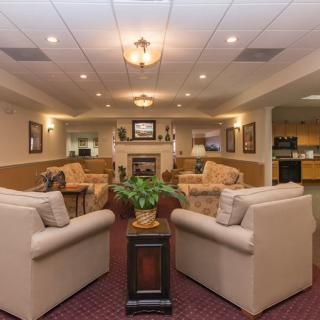 A cozy lobby with comfortable sofas and a fireplace in a warmly lit interior.