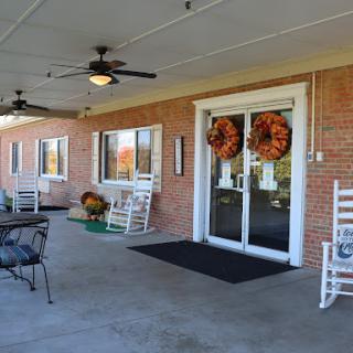 A welcoming entrance with autumn wreaths and a cozy porch setting.