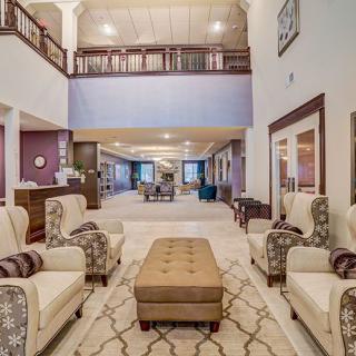 A spacious hotel lobby with elegant furniture and warm decor.