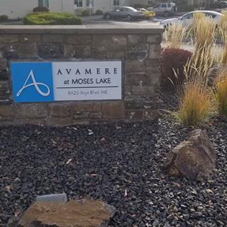 A landscaped sign for Avamere at Moses Lake surrounded by rocks and ornamental grass.