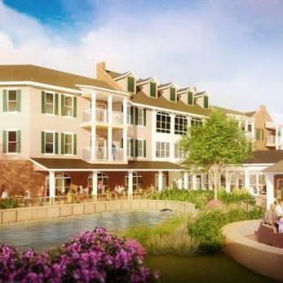 A picturesque building with a landscaped garden and people enjoying the outdoor space.