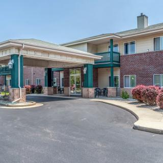 The exterior view of a hotel with a covered entrance and parking area.