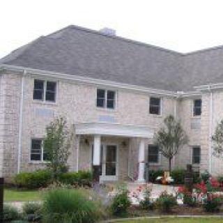 A two-story residential home with a landscaped front yard.