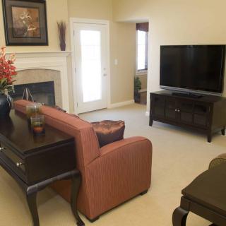 A cozy living room with a sofa, television, and fireplace.