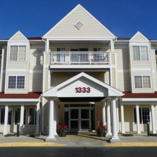 Front view of a hotel building with columns and a symmetrical design.
