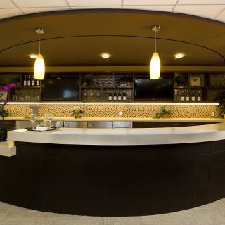 A modern bar interior with a sleek counter and ambient lighting.