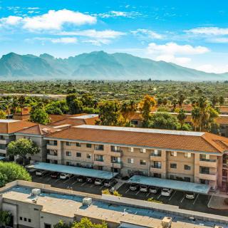 A scenic view of a building complex with mountains in the background on a clear day.
