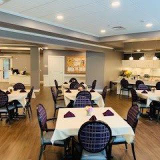 A spacious and elegantly set dining area with neatly arranged tables and chairs, featuring a modern interior design.