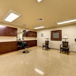 A tidy salon interior with chairs, a mirror, and soft lighting.