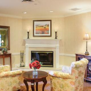 A cozy living room with a fireplace, two armchairs, and elegant decor.