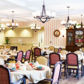 An elegant dining room with neatly arranged tables and chandeliers.