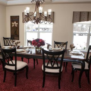 A beautifully arranged dining room featuring a wooden table, elegant chairs, and a stunning chandelier.