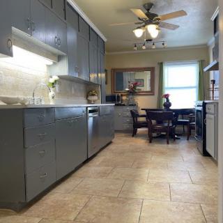 A modern kitchen with sleek cabinets and an adjoining dining area.