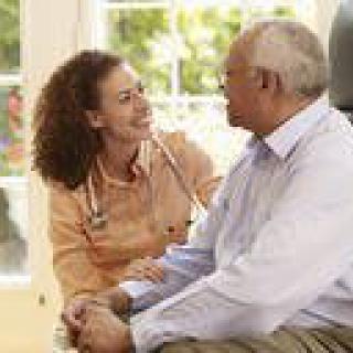 A healthcare professional interacting with an elderly patient at home.