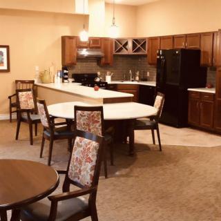 A cozy kitchen and dining area featuring a large island with seating, surrounded by wooden cabinets and modern appliances.