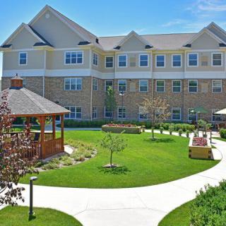 A well-maintained residential building with a central garden featuring a gazebo and pathways.