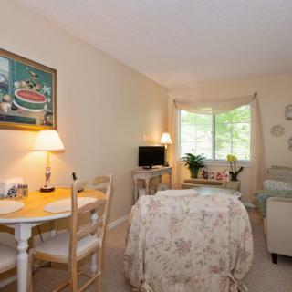 A cozy living room with a small dining table, chairs, and a comfortable seating area by the window.