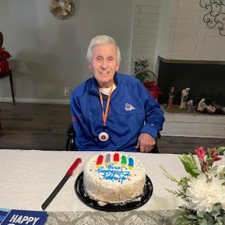 A joyful celebration with a birthday cake and a smiling individual wearing a medal.