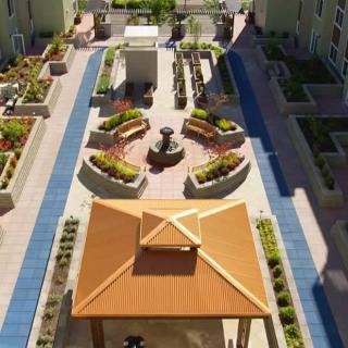 A beautifully designed rooftop garden featuring a central gazebo, fountain, and landscaped planters with surrounding pathways.