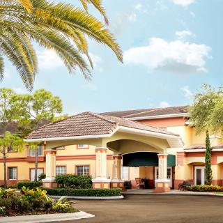 A hotel entrance surrounded by palm trees and well-maintained landscaping.