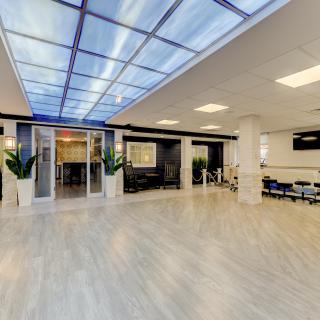 A modern and spacious office lobby with a glass ceiling and seating area.