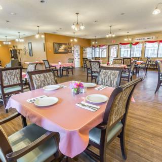 An empty dining room with neatly set tables and chairs, ready for guests.