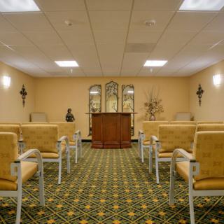 An empty chapel with rows of seating and a pulpit at the front.