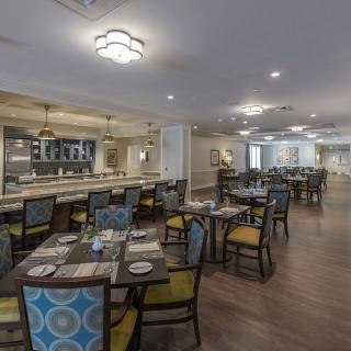 A spacious and elegantly designed restaurant interior with neatly arranged tables and chairs.
