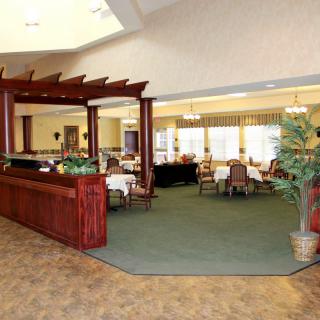 A spacious lobby with a reception desk leading into a dining area.