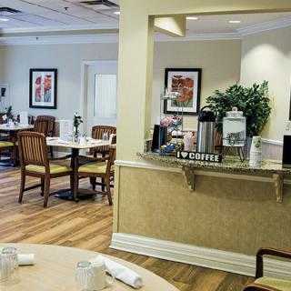 A cozy dining area with tables and chairs, featuring a coffee station and elegant decor.