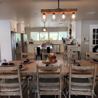 A modern open kitchen and dining area featuring a central island and large dining table.