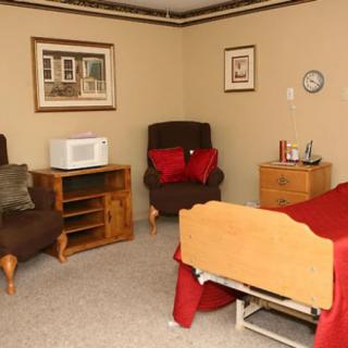 A cozy room with a single bed, chairs, and a microwave.