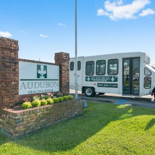 Entrance to the auditorium with a transportation bus parked nearby.