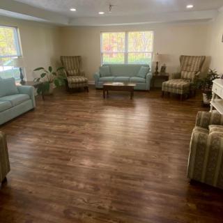 A cozy living room with sofas, chairs, and a wooden floor.