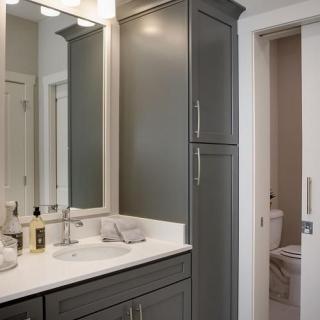 A modern bathroom with a sleek cabinet, mirror, and elegant lighting.