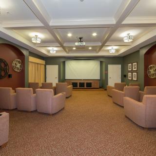 A cozy home theater room with comfortable chairs and a large screen.