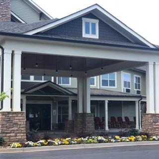 A residential building entrance with landscaping and flowers.