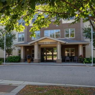 A view of a building entrance surrounded by trees.