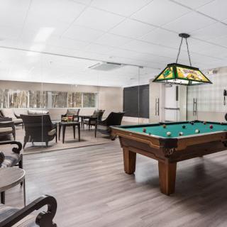 A modern recreational room with a pool table and seating area.