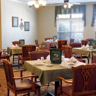 A cozy dining room setup with neatly arranged tables and chairs.