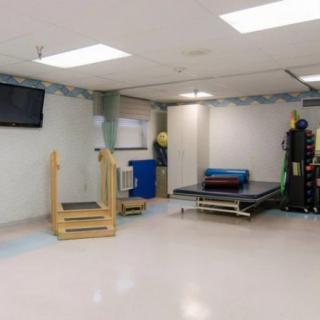 A rehabilitation room equipped with various physical therapy tools and exercise equipment.